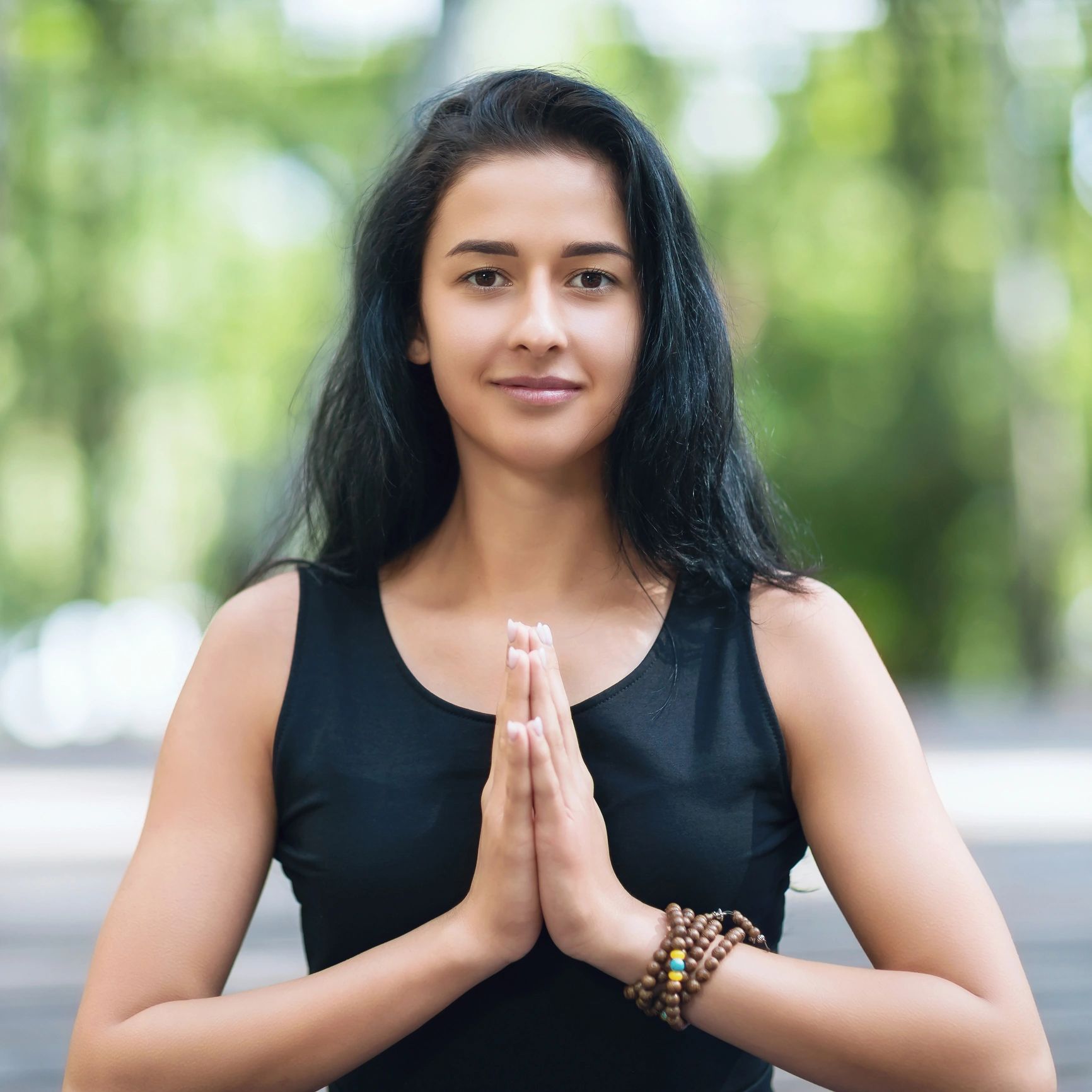 Yoga instructor portrait outdoors with hands together